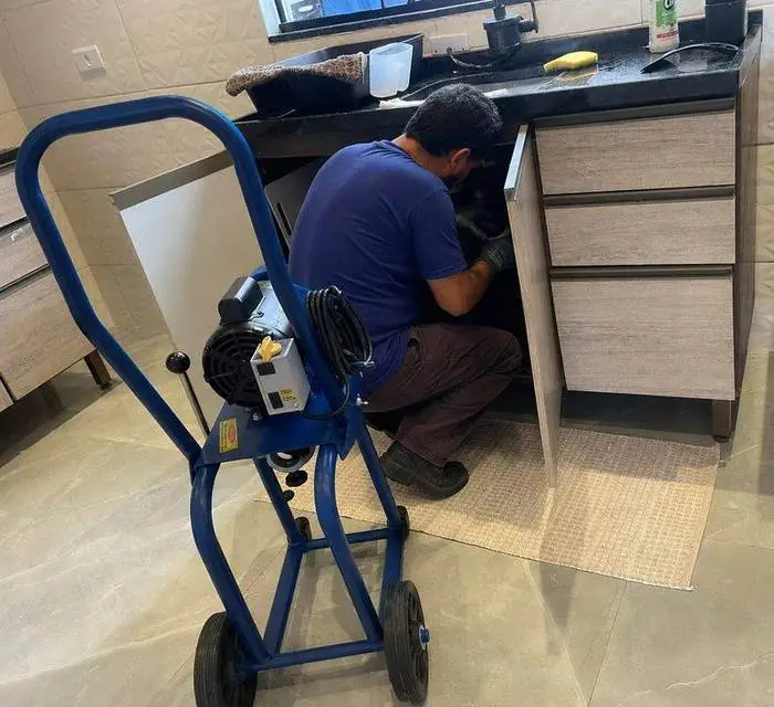 Profissional da Desentupidora Hidropró realizando desentupimento de pia